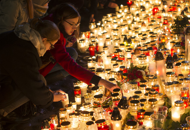 Candles are placed outside the French embassy in Vilnius, Lithuania, Saturday, Nov. 14, 2015, for the victims in Friday's attacks in Paris. French President Francois Hollande said more than 120 people died Friday night in shootings at Paris cafes, suicide bombings near France's national stadium and a hostage-taking slaughter inside a concert hall. (AP Photo/Mindaugas Kulbis)